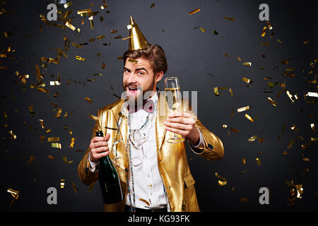 Uomo gioioso bevendo champagne Foto Stock