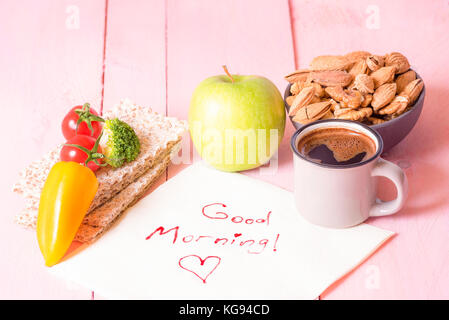 Nutriente colazione con pane croccante detto Knäckebrot, verdure, frutta, una tazza di mandorle, noci, una tazza di caffè su un tovagliolo con la buona mattina parole, su un pi Foto Stock