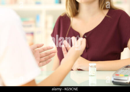 Close up di un farmacista e cliente in una farmacia scrivania Foto Stock