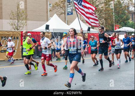 New york, Stati Uniti d'America. 5 novembre, 2017. una femmina di runner che porta una bandiera degli Stati Uniti nella maratona di New York il 5 novembre del 2017 vicino al 20 mile marker nel Bronx, NY credit: brigette supernova/alamy live news Foto Stock