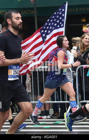 La città di New York, New York, Stati Uniti d'America. 5 Novembre, 2017. Una donna che tiene una bandiera americana come lei corre fino 1° Avenue a Manhattan durante la maratona di New York. Credito: Nancy Kaszerman/ZUMA filo/Alamy Live News Foto Stock