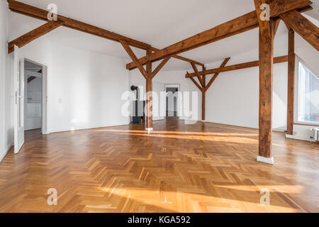 Vuoto loft camera con camino e travi in legno - Foto Stock