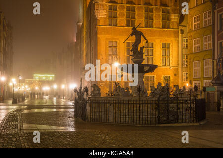 La fontana del Nettuno nella città vecchia di Danzica nella nebbia di notte. La Polonia. Foto Stock