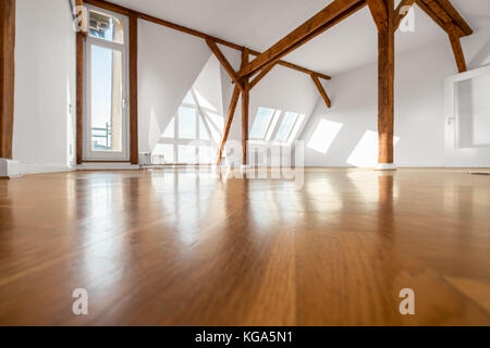 Stanza vuota con pavimento in legno e travi del tetto - mansarda Foto Stock