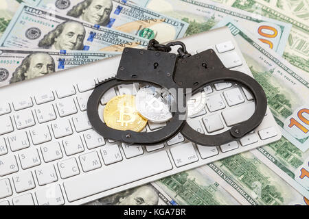 Mosca, Russia - 5 novembre 2017: acciaio manette e monete di cryptocurrency giacente al di sopra della tastiera del computer Foto Stock