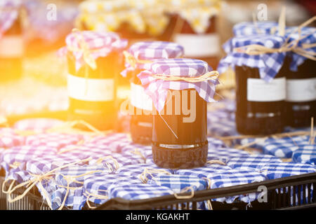 Molti barattoli per conserve con marmellata di scuro in un mercato. shot orizzontale Foto Stock