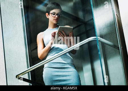 Ritratto di attraente giovane imprenditrice utilizzando tablet Foto Stock
