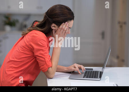 Tesi donna che lavorano su computer portatile alla reception Foto Stock