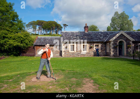 Statua di agricoltore in erba a Fattorie Tradizionali di Muckross ingresso, Muckross House e giardini, Parco Nazionale di Killarney, nella contea di Kerry, Irlanda Foto Stock