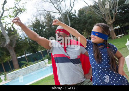 Sorridente padre e figlia fingendo di essere un supereroe Foto Stock