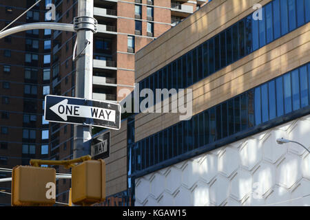 Un modo cartello stradale punti a sinistra su una new york city street, con edifici alti oltre Foto Stock