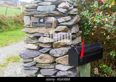 Stile Americano postbox accanto a secco di un muro di pietra nel paese in Ballydehob, West Cork, Irlanda. Foto Stock