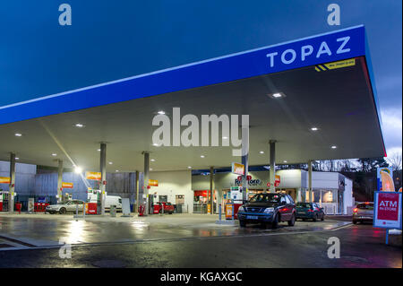 Garage della stazione di riempimento e il piazzale antistante al crepuscolo in Bantry, West Cork, Irlanda con un cielo blu. Foto Stock