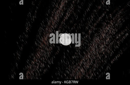 Una luna al 99% con fuochi d'artificio in primo piano su Whitley Bay, Tyne e Wear. Foto Stock