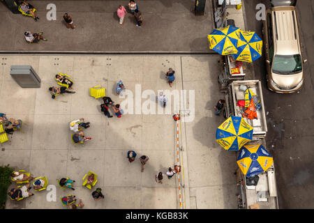 Vista da sopra come i newyorkesi sono godendo il loro pranzo nella parte anteriore del camion il pranzo sulla strada della città di New York, New York. Foto Stock