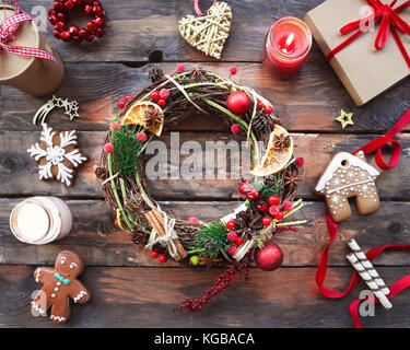 Sfondo di natale con decorazioni, corona, confezione regalo e candele Foto Stock