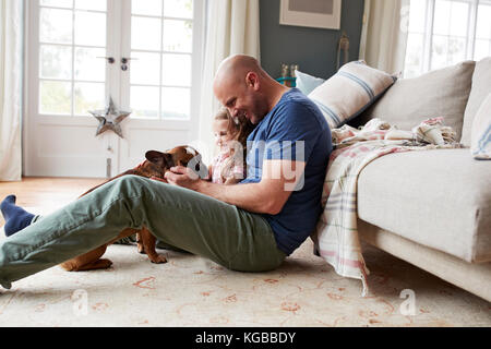 Padre e figlia rilassante con il loro cane a casa Foto Stock