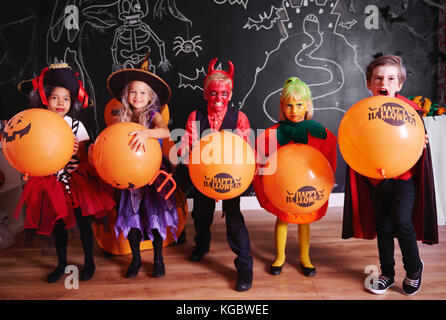 I bambini in costume in piedi in fila e in posa Foto Stock