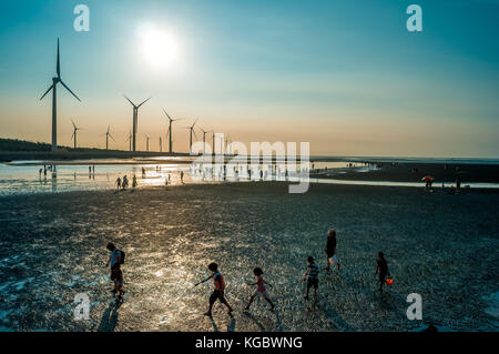 Sillouette di turbina eolica array a seashore wetland Foto Stock