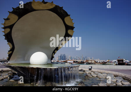 Doha, Qatar - 6 novembre 2017: la Oyster e pearl fontana sulla Corniche, con i lontani business torri in West Bay Foto Stock