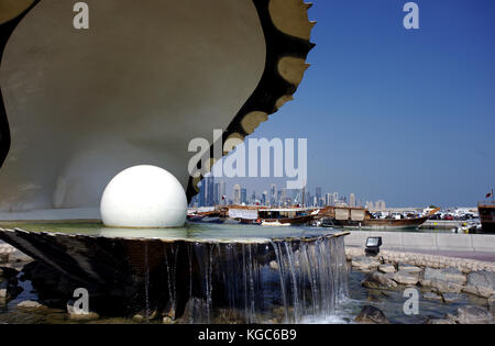 Doha, Qatar - 6 novembre 2017: la Oyster e pearl monumento sulla Corniche, con le lontane torri di business Foto Stock