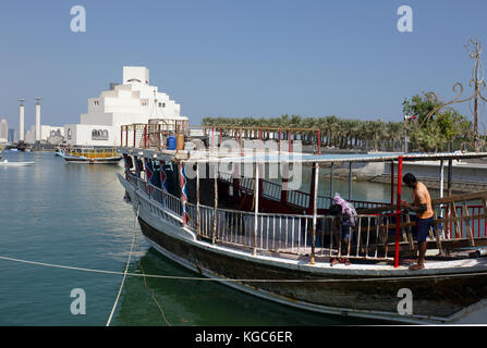 Doha, Qatar - 6 novembre 2017: operai mantenere un dhow ormeggiati su Doha corniche di fronte il museo di arte islamica Foto Stock