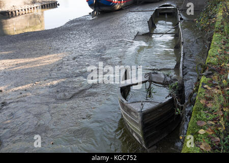 Barca abbandonata immersa nel fango, sul fiume Tamigi a St Margarets, a sud-ovest di Londra, Inghilterra, durante il fiume annuali di disegnare su off Foto Stock