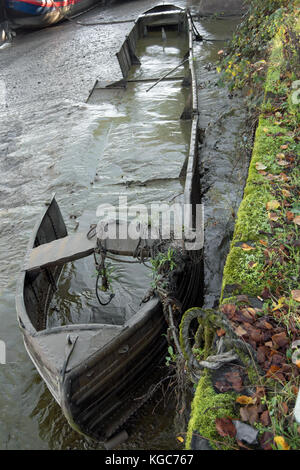 Barca abbandonata immersa nel fango, sul fiume Tamigi a St Margarets, a sud-ovest di Londra, Inghilterra, durante il fiume annuali di disegnare su off Foto Stock