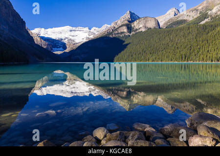 Il Monte Victoria e il ghiacciaio si riflette nell'acqua colorata del Lago Louise, Alberta, Canada Foto Stock