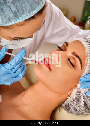 Iniezione di riempimento per le femmine di fronte faccia. plastica estetica chirurgia facciale nella clinica di bellezza. medico in guanti medicali con siringa inietta labbra augme Foto Stock