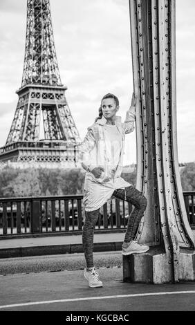 Anno fit & hip a Parigi. giovani montare donna contro la Torre Eiffel a Parigi cercando la distanza Foto Stock