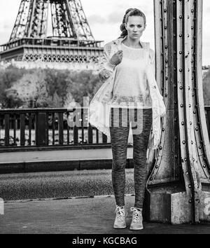 Anno fit & hip a Parigi. a piena lunghezza Ritratto di giovane donna di mettere in piedi contro la Torre Eiffel a Parigi Foto Stock