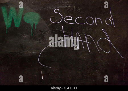 Frammento di un muro nero con testo scritto da bianco a mano - di seconda mano Foto Stock