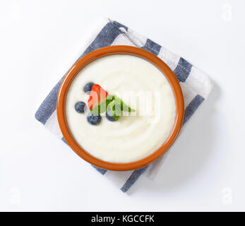 Ciotola di budino di semolino con frutta fresca su striped igienico Foto Stock
