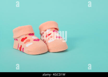 Rosa Baby girl calza con cuori colorati su sfondo blu Foto Stock