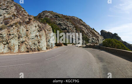 Corsica: la tortuosa strada attraverso le scogliere a strapiombo sul mare mediterraneo del lato ovest del Cap Corse, la penisola settentrionale Foto Stock