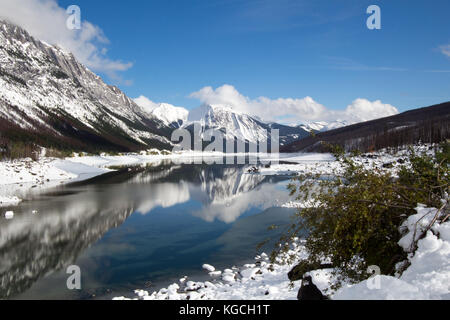 Riflessioni, montagne e neve, medicina lago nel parco nazionale di Banff, Alberta, Canada Foto Stock