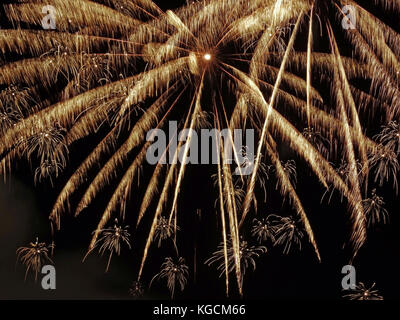 Grande display di colore giallognolo fuochi d'artificio - due grandi e numerosi piccoli Foto Stock