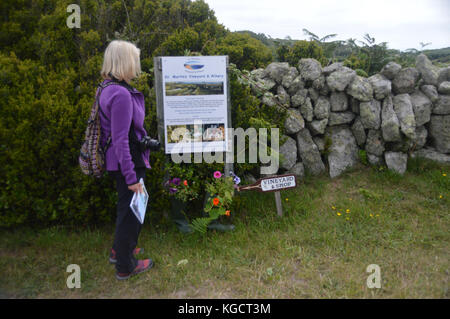 Lone donna escursionista guardando a segno per St Martins vigna & cantina sull'isola di St Martin's nelle isole Scilly, Regno Unito. Foto Stock