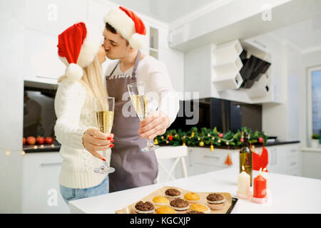 Un paio di santa claus cappelli con bicchieri di champagne per natale Foto Stock