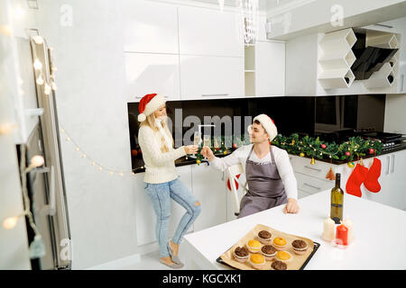 Un paio di santa claus cappelli con bicchieri di champagne per natale Foto Stock