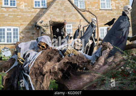 Scheletri di Halloween e Grim Reaper al di fuori di una casa in Snowshill, Cotswolds, Gloucestershire, Inghilterra Foto Stock