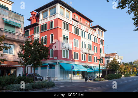 Appartamento colorato blocco su Granviale Santa Maria Elisabetta, Lido di Venezia Lido, Venezia, Italia con negozi di seguito in autunno nella luce della sera Foto Stock