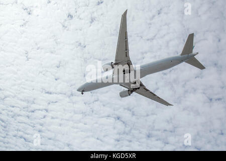 Aereo di linea commerciale che vola sopra la testa preparandosi per l'atterraggio a LAX con le nuvole brillanti nello sfondo Foto Stock