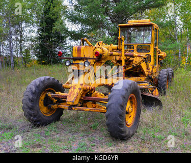 Rusty vecchia strada escavatore parcheggiato in una radura nel deserto Adirondack. Foto Stock