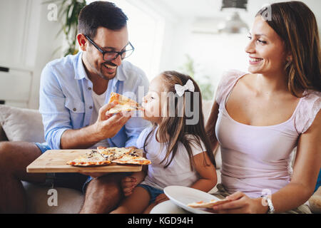 Felice Condivisione in famiglia pizza insieme a casa Foto Stock