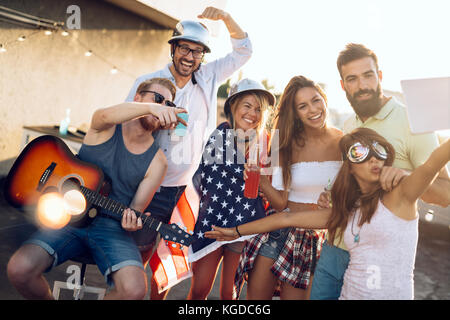 Gruppo di amici felice avente parte sul tetto Foto Stock