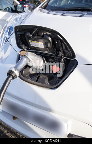 La Nissan Leaf auto elettrica in corrispondenza di un punto di ricarica in corrispondenza di una stazione di servizio autostradale Foto Stock