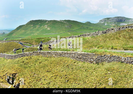 I ciclisti andare in bicicletta nelle valli dello Yorkshire Regno Unito viaggiando attraverso il bellissimo paesaggio vicino a Settle Foto Stock