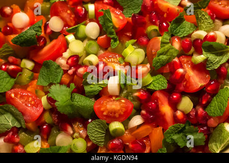 Primo piano del piatto per insalata di Fattoush libanese mediorientale, pomodori ciliegini, menta, cipolla primaverile, semi di melograno e verdure Foto Stock